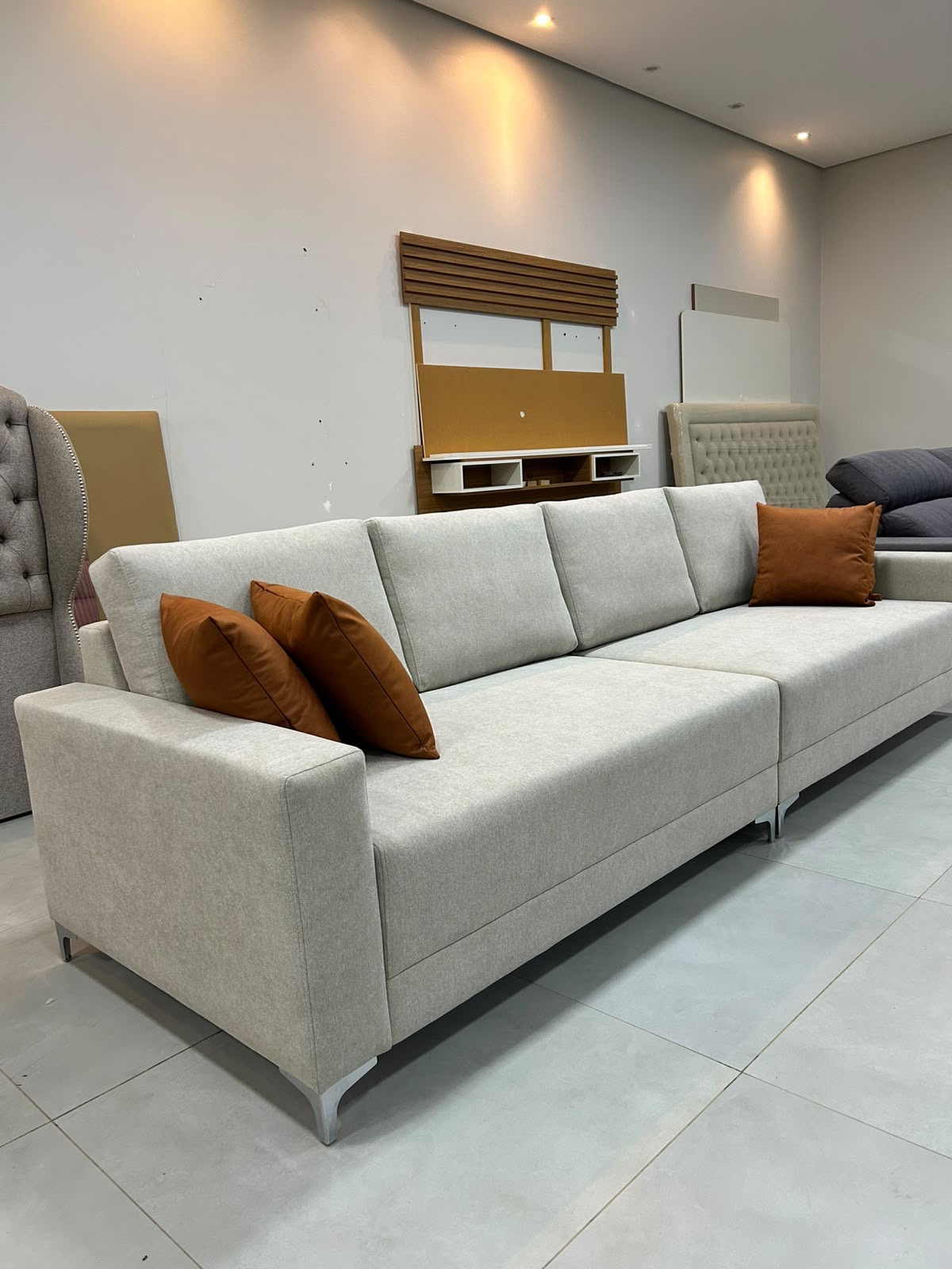 Sofá living cinza-claro com almofadas terrosas